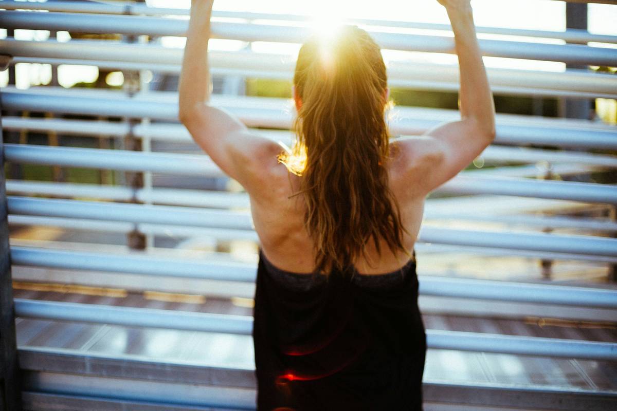 Woman in yoga pose wearing breathable headband as part of active hair trend