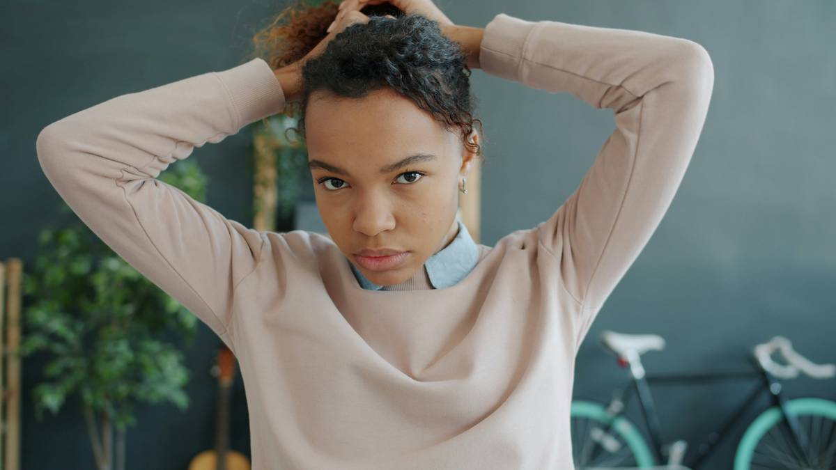 Woman in yoga pose with an adaptable updo secured by matte bobby pins and a spiral hair tie