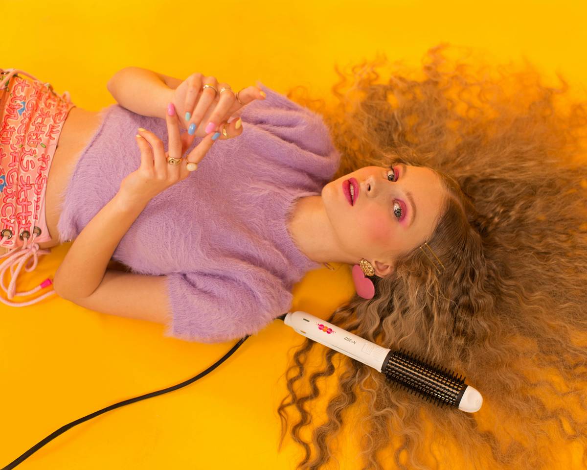 Woman in downward dog pose wearing an energetic hair style: a neat, low twisted bun secured with fabric scrunchies